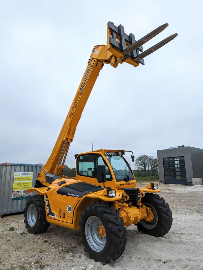Yellow telescopic forklift lifting arm on a cloudy day at a construction site in Meppen, Germany.