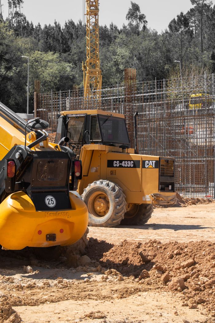 Active construction site with bulldozers and cranes working on a building project.