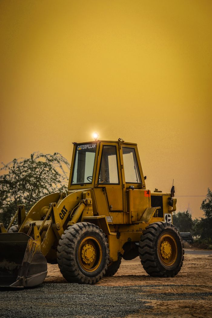 Yellow front loader parked at a construction site in Layyah, Punjab. Dusty evening ambiance.