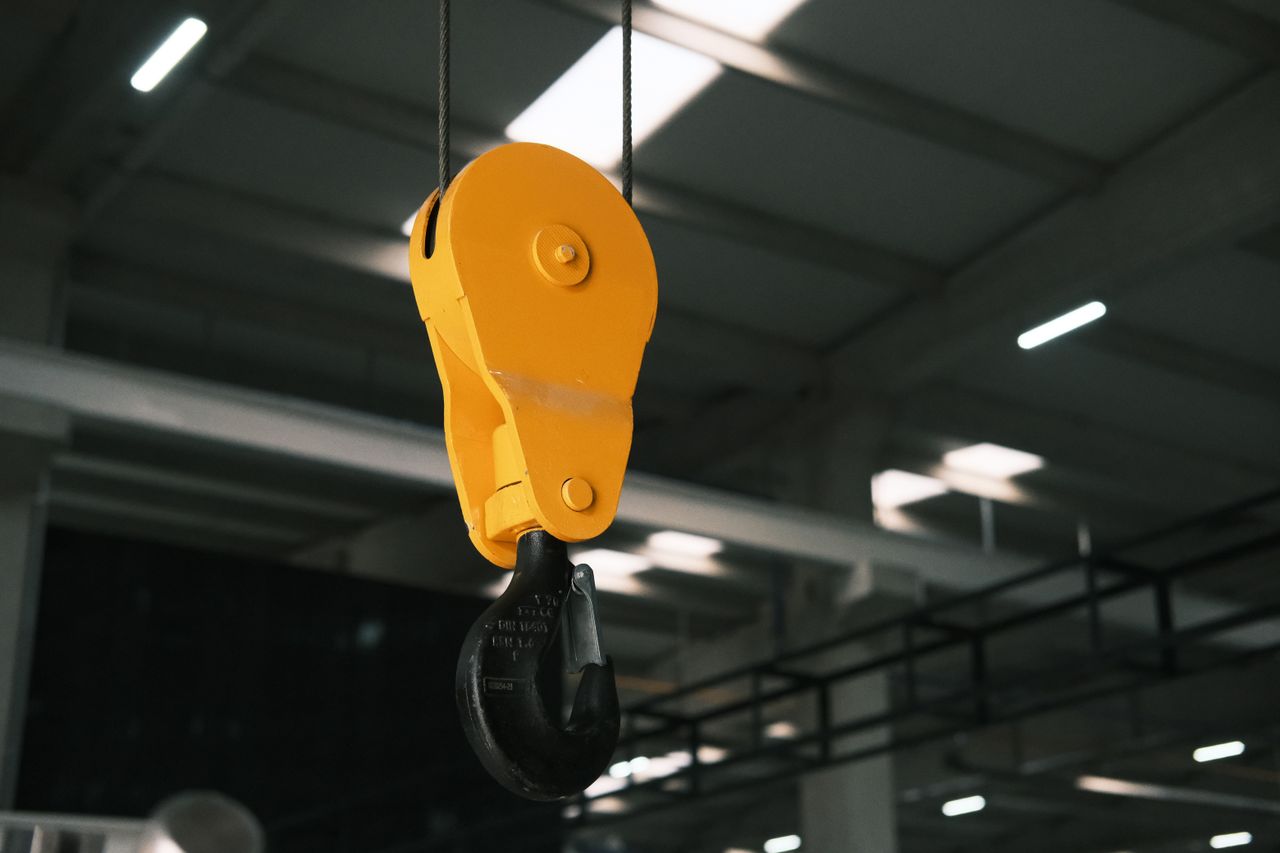 Close-up view of a yellow crane hook in an industrial factory setting in Konya, Türkiye.